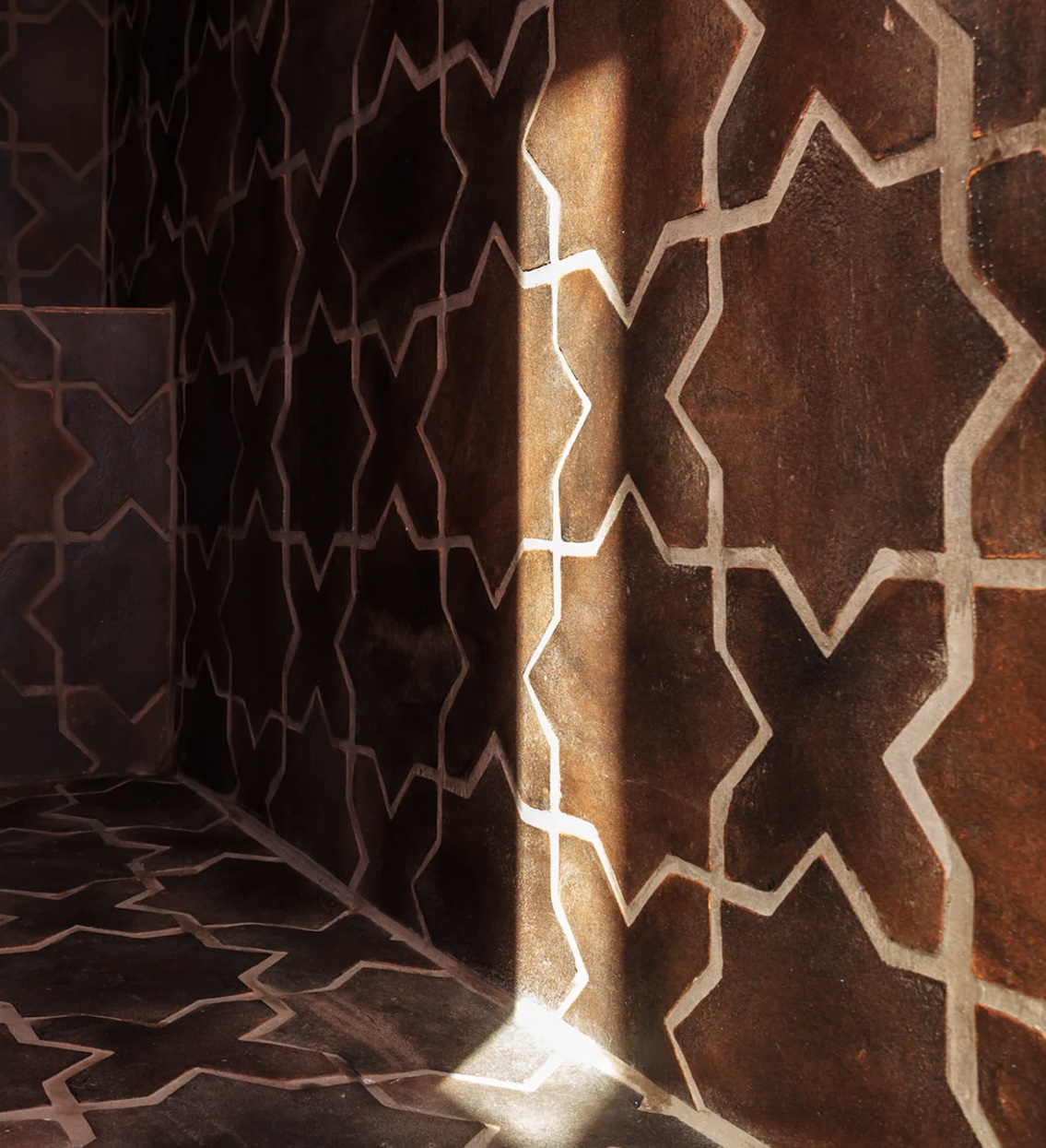 Dark geometric tile detail in a steam room